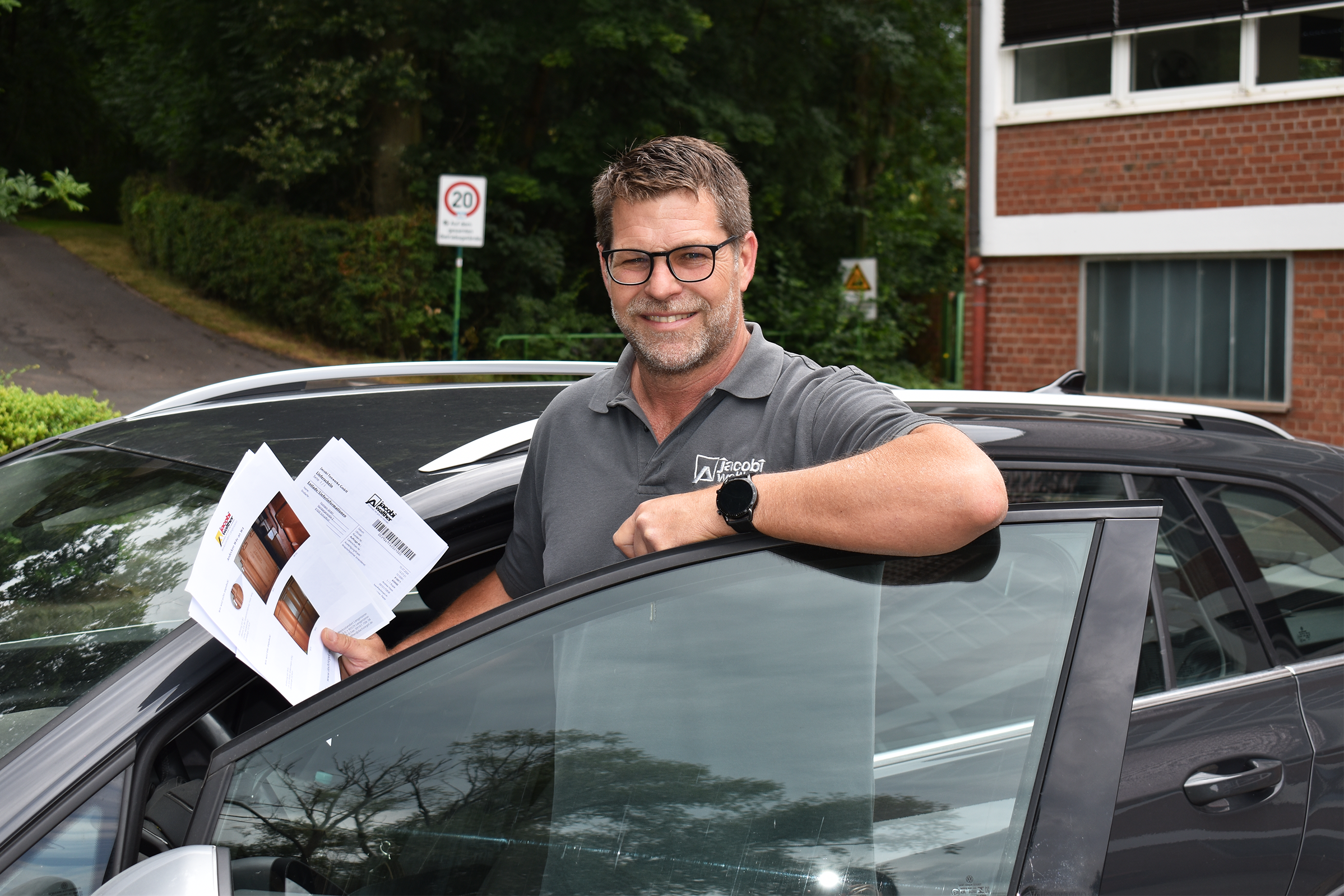 Außendienstkollege steht an seinem Dienstfahrzeug