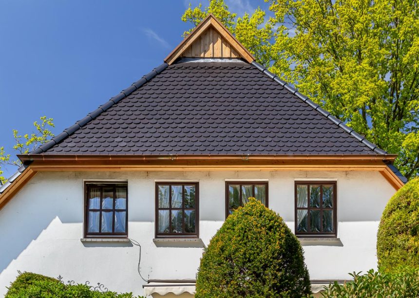 Traditionelles Einfamilienhaus mit Krüppelwalmdach, gedeckt mit Biberschwanzziegel in edelschwarz