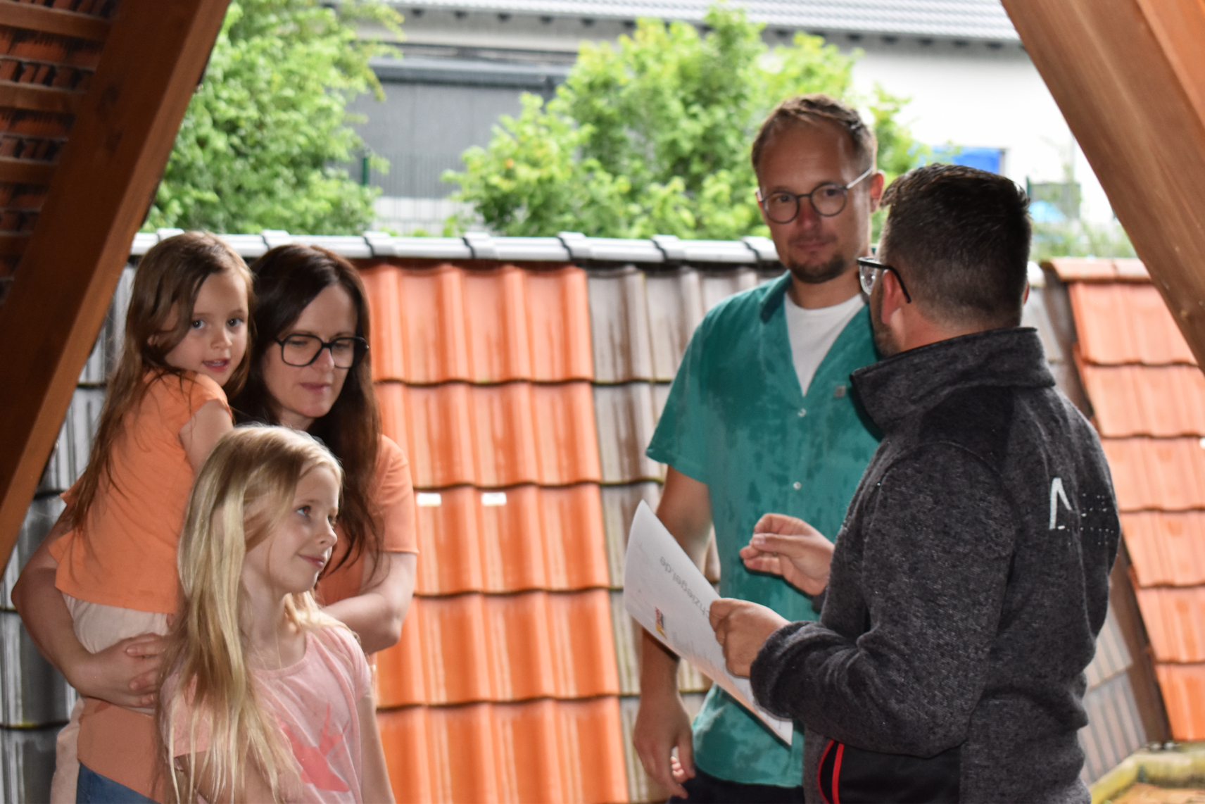 Außendienstkollege in einem Beratungsgespräch mit einer Familie im Dachziegel-Musterpark