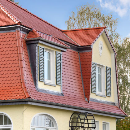 Einfamilienhaus mit Mansarddach, gedeckt mit Biberschwanzziegel in rotbraun