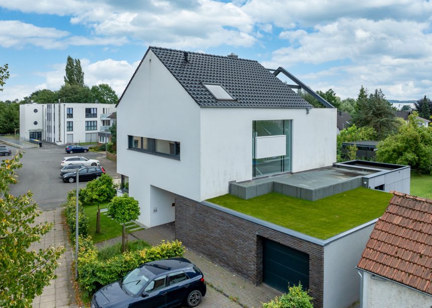 Einfamilienhaus mit Flachdachziegel J11v in edelschwarz in der Gesamtansicht mit begrüntem Garagendach