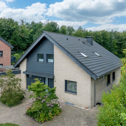 Saniertes Klinkerhaus mit Klassiker J11v im modernen altschwarz auf dem Satteldach in der Gesamtansicht aus der Luft